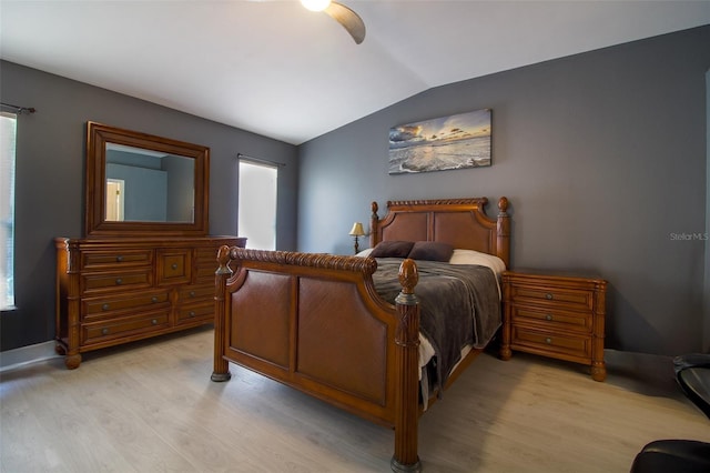 bedroom with ceiling fan, light wood-type flooring, and vaulted ceiling