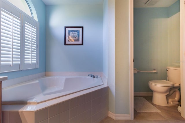 bathroom with tile patterned floors, toilet, and tiled tub