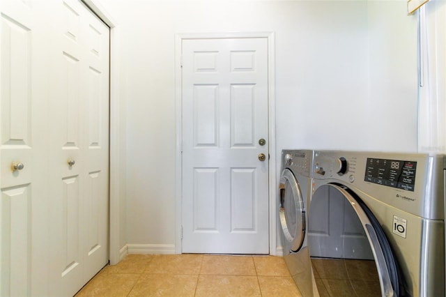 clothes washing area featuring separate washer and dryer and light tile patterned floors