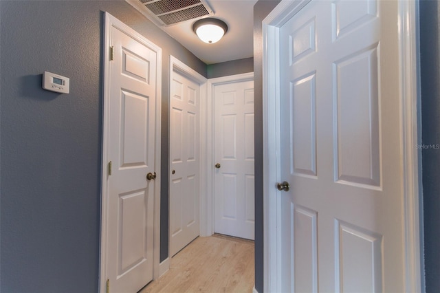 corridor with light hardwood / wood-style floors