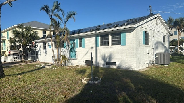 back of house with a lawn and central AC