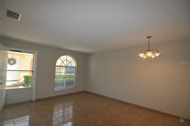 spare room featuring a chandelier