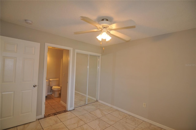 unfurnished bedroom with a textured ceiling, connected bathroom, a closet, and ceiling fan