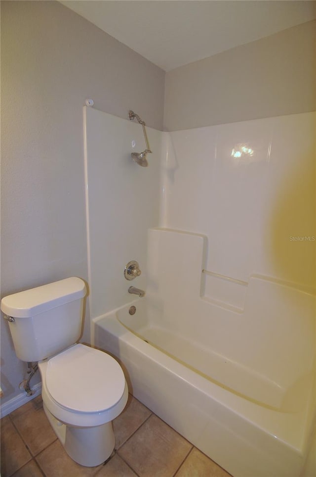 bathroom featuring toilet, tile patterned floors, and shower / washtub combination