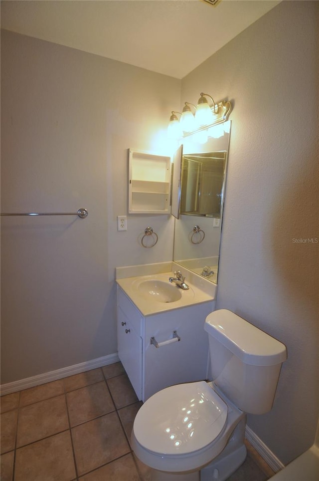 bathroom with tile patterned flooring, vanity, and toilet