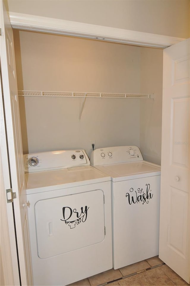 laundry area with washer and dryer and light tile patterned floors