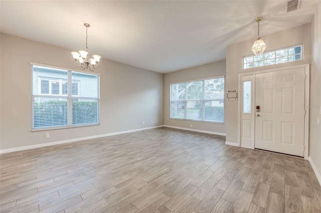 foyer entrance featuring light hardwood / wood-style flooring and a notable chandelier