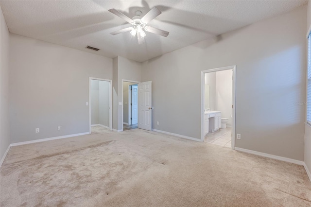 carpeted spare room featuring a towering ceiling, a textured ceiling, and ceiling fan