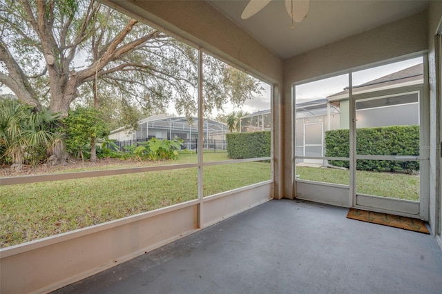 unfurnished sunroom with ceiling fan