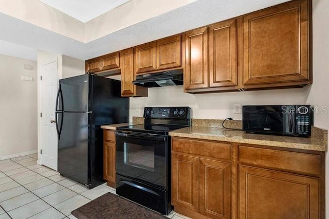 kitchen featuring black appliances, light tile patterned flooring, and light stone countertops