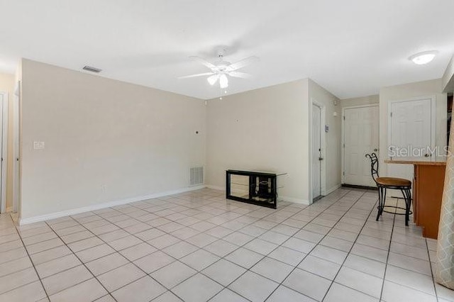 unfurnished living room with ceiling fan and light tile patterned floors