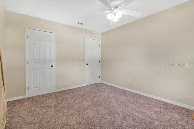 carpeted empty room featuring ceiling fan