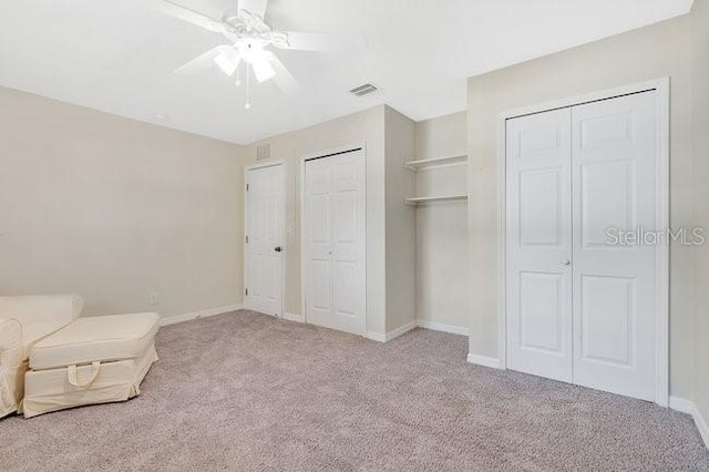unfurnished room with ceiling fan and light colored carpet