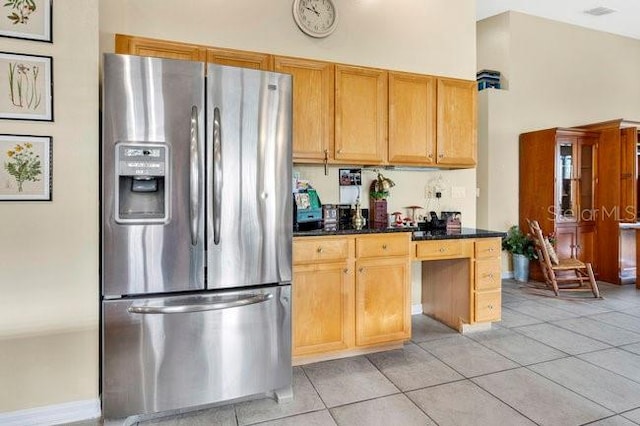 kitchen with light tile patterned floors, high vaulted ceiling, and stainless steel refrigerator with ice dispenser