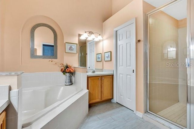 bathroom featuring shower with separate bathtub and vanity