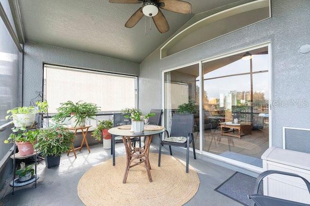 sunroom / solarium with lofted ceiling, plenty of natural light, and ceiling fan