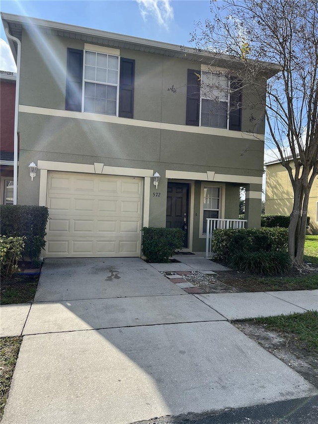 view of property with a porch and a garage