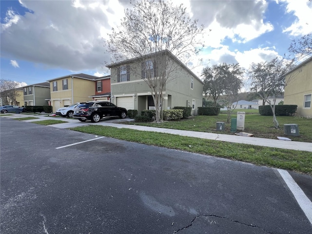 view of parking / parking lot with a lawn and a garage