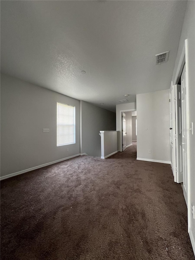 carpeted spare room featuring a textured ceiling