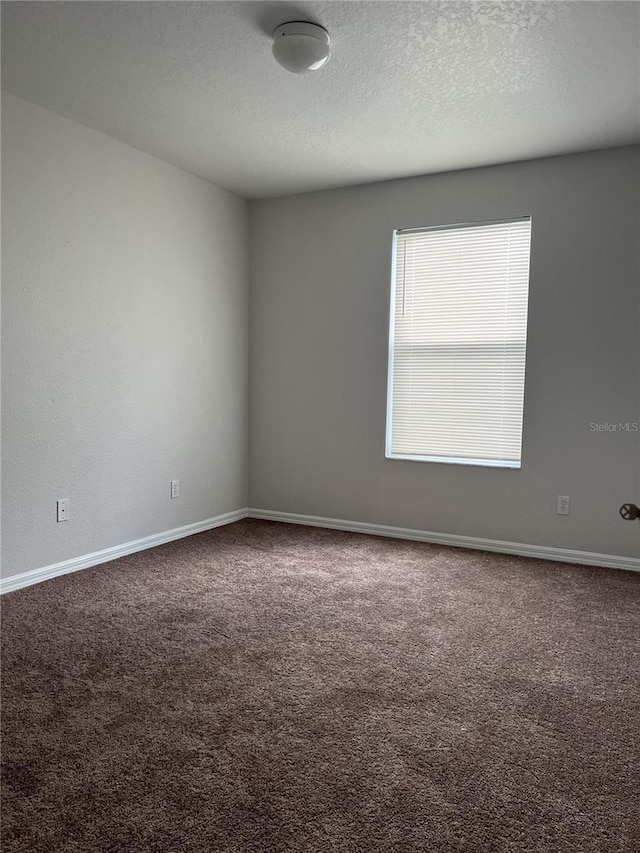 carpeted spare room featuring a textured ceiling