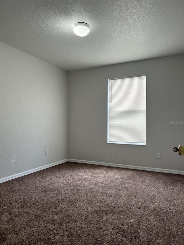 unfurnished room featuring carpet floors and a textured ceiling