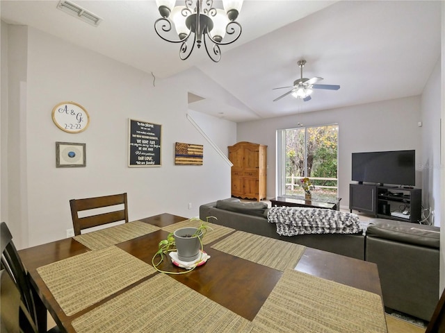 dining area with ceiling fan with notable chandelier and lofted ceiling