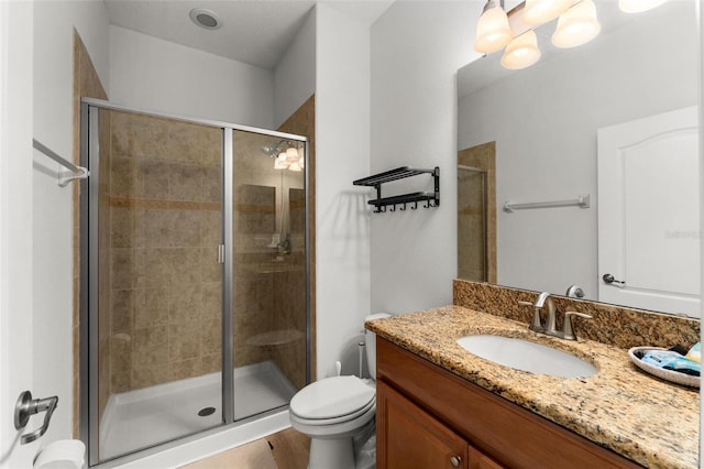 bathroom featuring vanity, an enclosed shower, and toilet