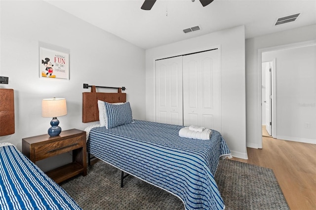 bedroom featuring hardwood / wood-style flooring, ceiling fan, and a closet