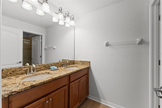 bathroom featuring a textured ceiling, vanity, hardwood / wood-style flooring, and walk in shower