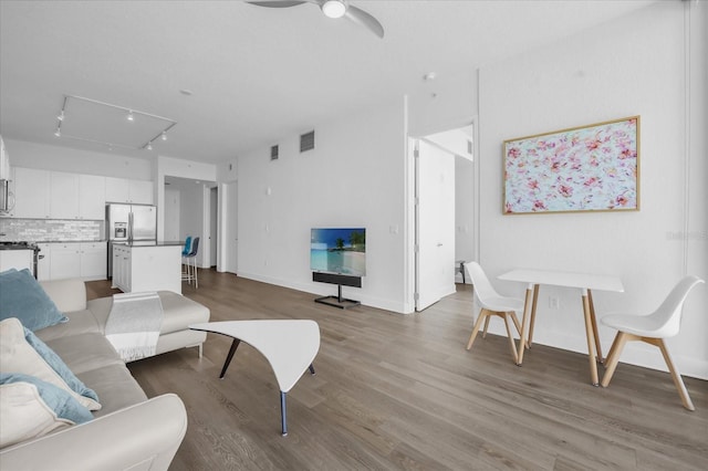 living room with ceiling fan, track lighting, and wood-type flooring