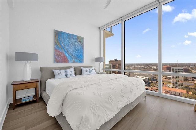 bedroom featuring hardwood / wood-style flooring and a wall of windows