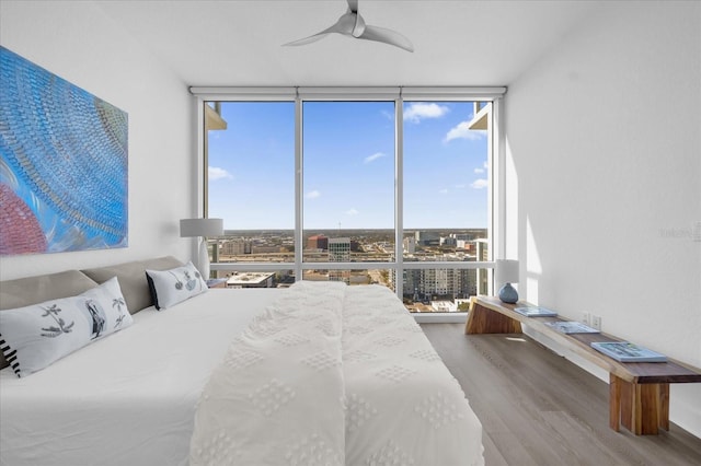 bedroom featuring floor to ceiling windows, ceiling fan, and hardwood / wood-style floors