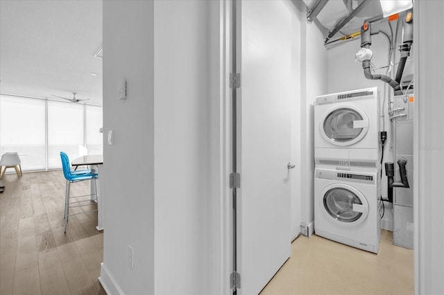 washroom featuring light wood-type flooring, ceiling fan, and stacked washer and clothes dryer