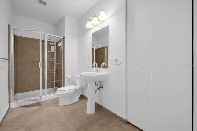 bathroom featuring toilet, tile patterned flooring, walk in shower, and sink