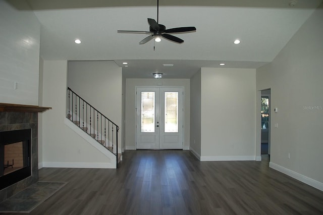 entryway featuring french doors, ceiling fan, dark hardwood / wood-style flooring, and a tiled fireplace