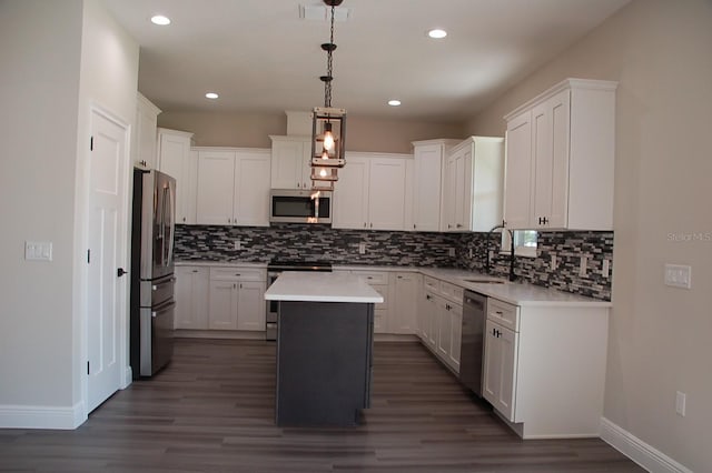 kitchen with stainless steel appliances, white cabinetry, a kitchen island, and pendant lighting