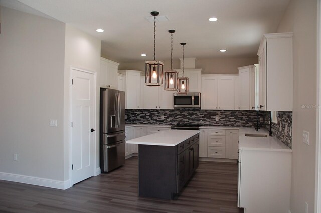 kitchen featuring sink, decorative light fixtures, a kitchen island, stainless steel appliances, and white cabinets