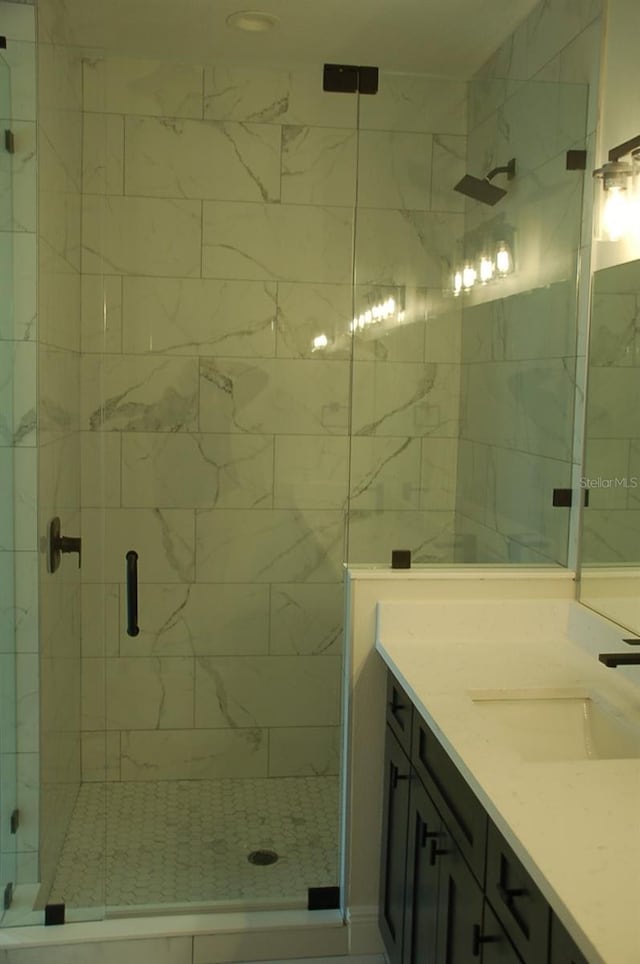 bathroom with vanity and a shower with door