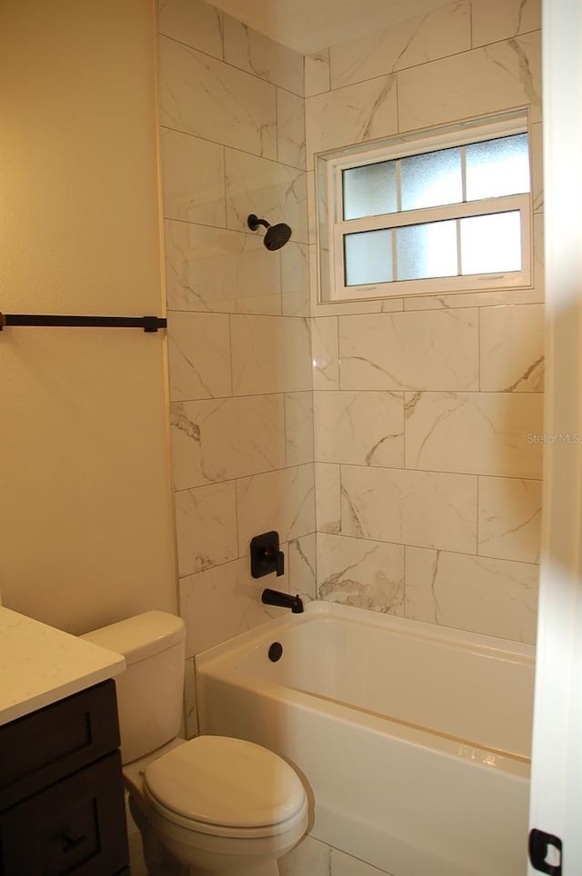 full bathroom featuring tiled shower / bath, vanity, and toilet