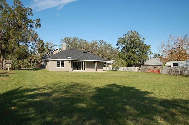 rear view of house featuring a yard