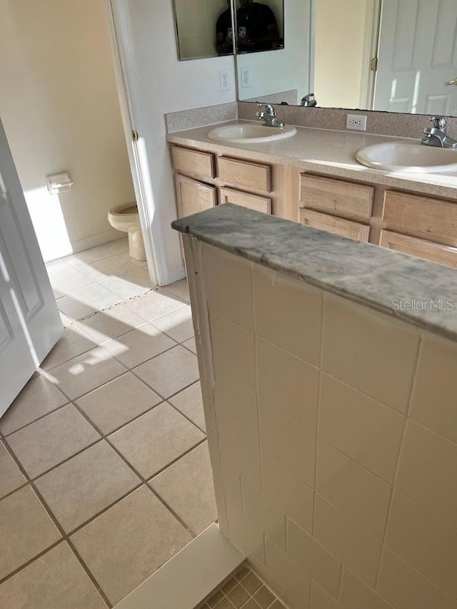 bathroom featuring toilet, vanity, and tile patterned floors