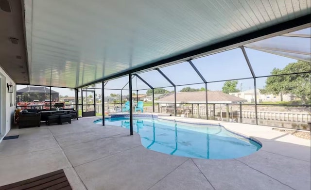 view of swimming pool with glass enclosure and a patio area