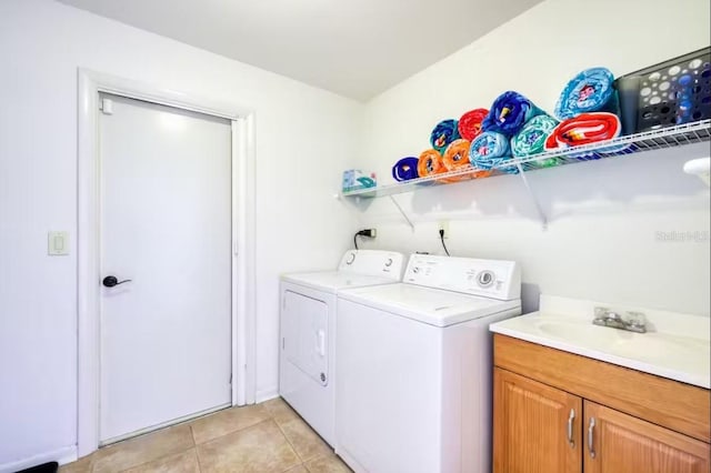 clothes washing area with cabinets, separate washer and dryer, sink, and light tile patterned floors