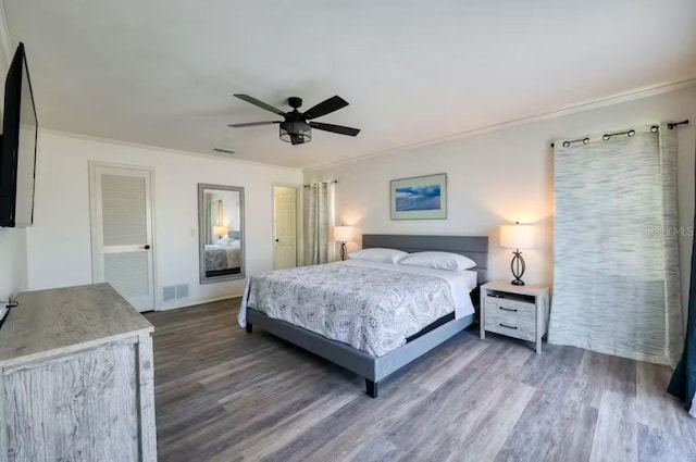 bedroom featuring ceiling fan, crown molding, and dark wood-type flooring