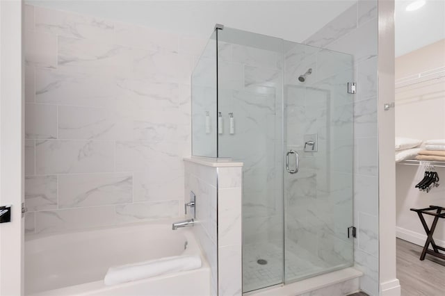 bathroom featuring hardwood / wood-style floors and separate shower and tub