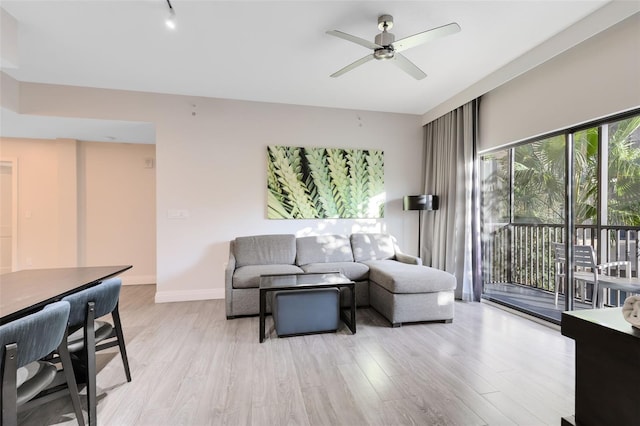 living room featuring light wood-type flooring and ceiling fan