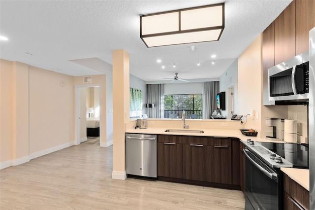 kitchen featuring ceiling fan, sink, light hardwood / wood-style flooring, dark brown cabinets, and appliances with stainless steel finishes