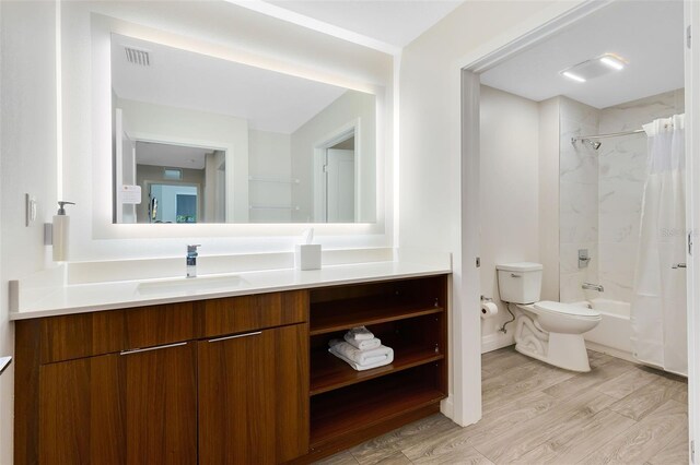 full bathroom featuring visible vents, shower / bath combo with shower curtain, toilet, wood finished floors, and vanity
