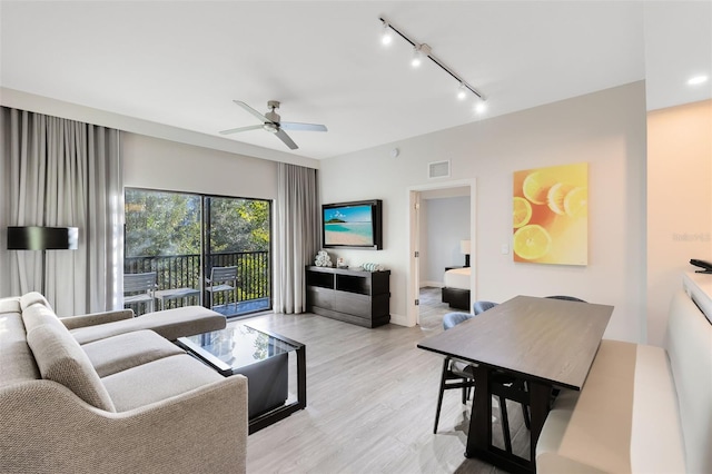 living area featuring a ceiling fan, visible vents, baseboards, light wood-style flooring, and track lighting