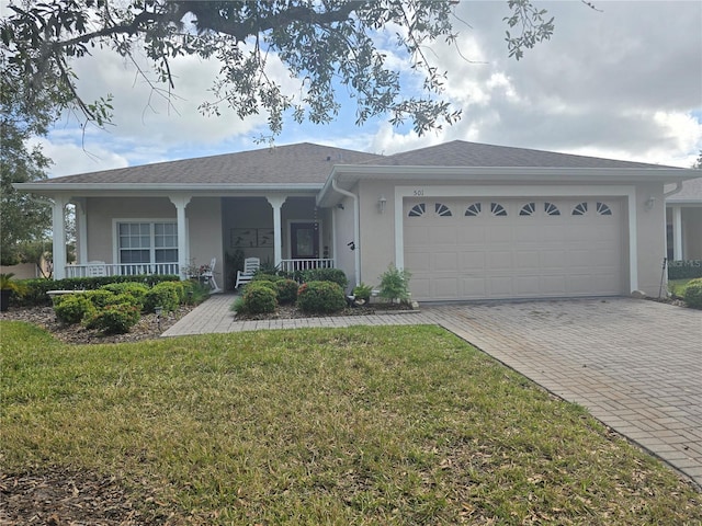 ranch-style house featuring covered porch, a garage, and a front yard